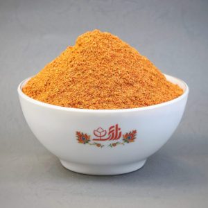 کاسه سفید چینی با لوگوی سوغات زارعی حاوی پودر ادویه کاری 32 قلم زعفرانی با رنگ نارنجی و بافت نرم