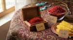 مجموعه کامل سوغات مشهد شامل زعفران، زرشک، نبات، فیروزه و نخود کشمش روی ترمه